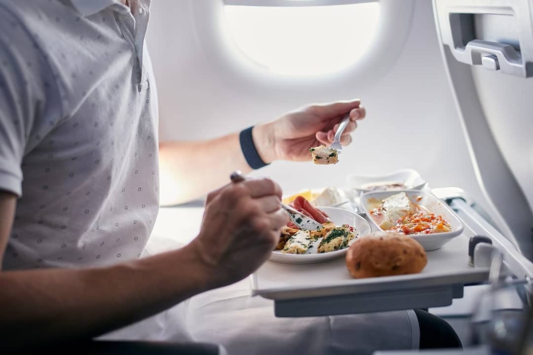 A passenger eating an airline meal during a short-haul flight.